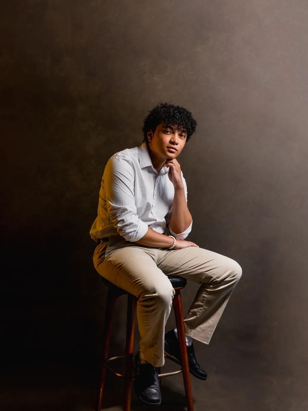 Studio portrait, seated on a stool