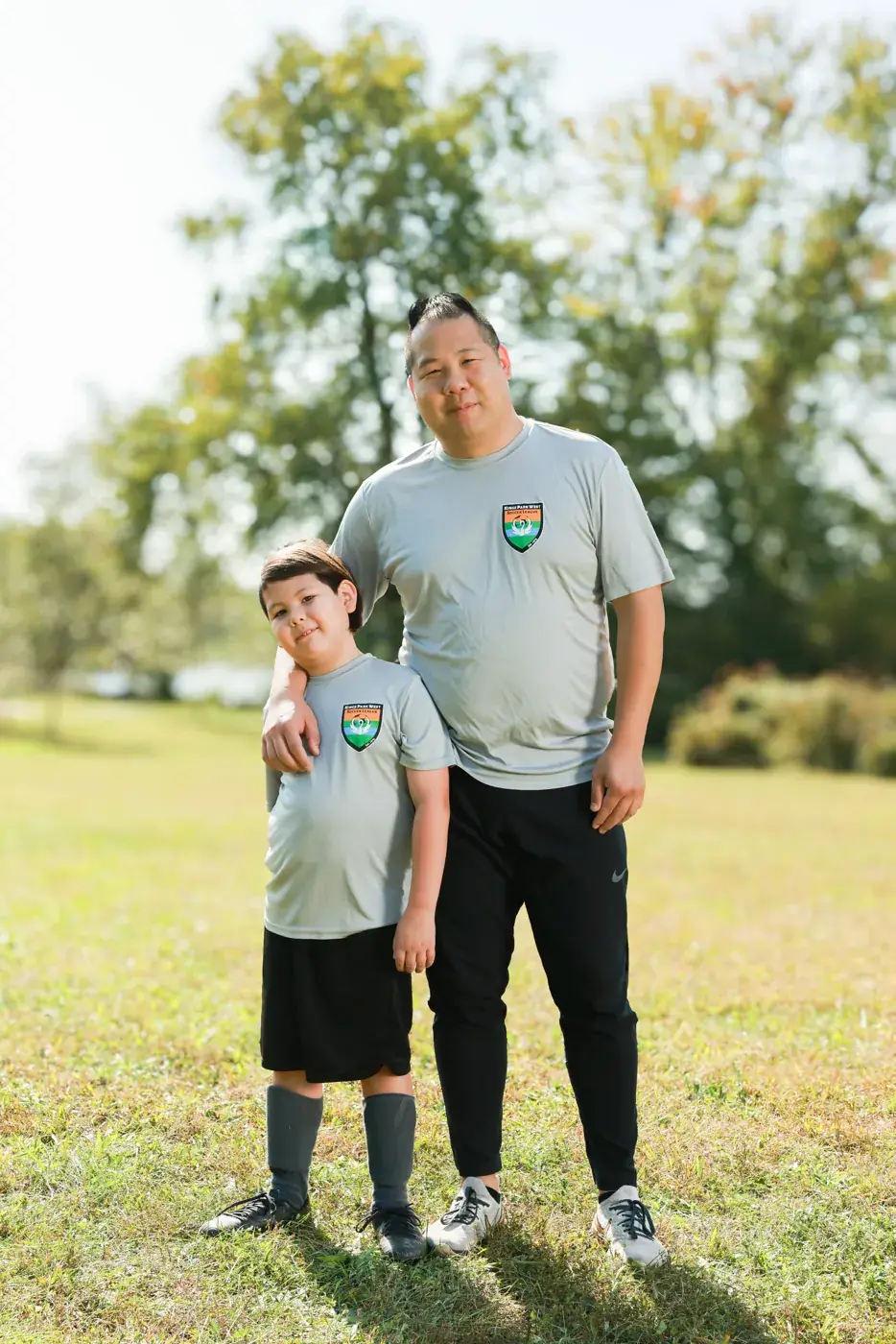 Father and son in matching soccer team shirts
