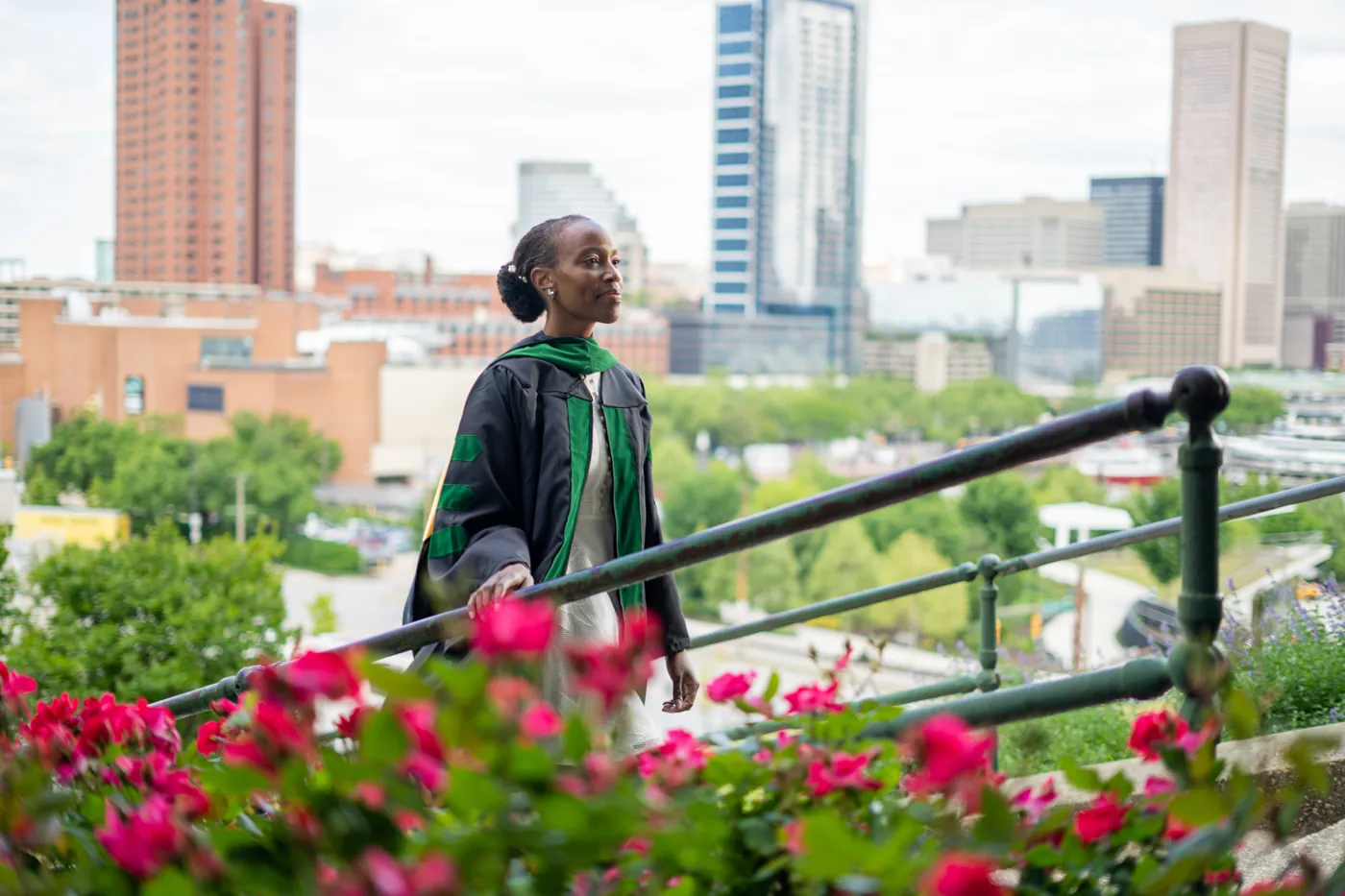 Graduate in academic regalia overlooking a city skyline