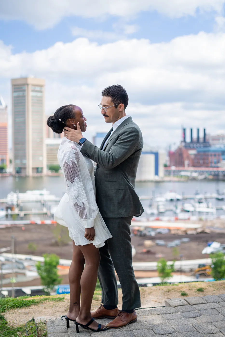 Engaged couple embracing on a rooftop overlooking the harbor