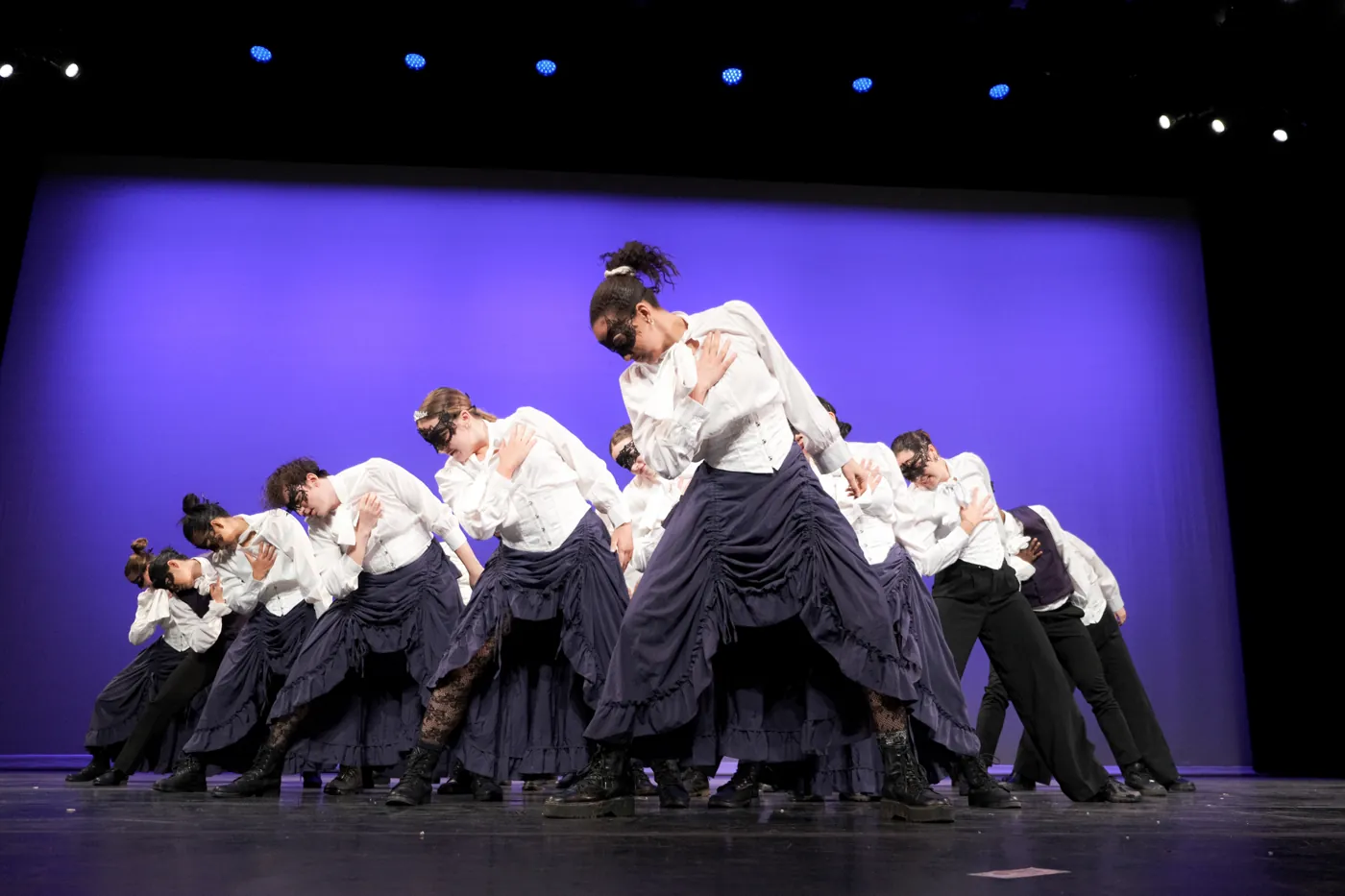 Dance ensemble in matching costumes on stage