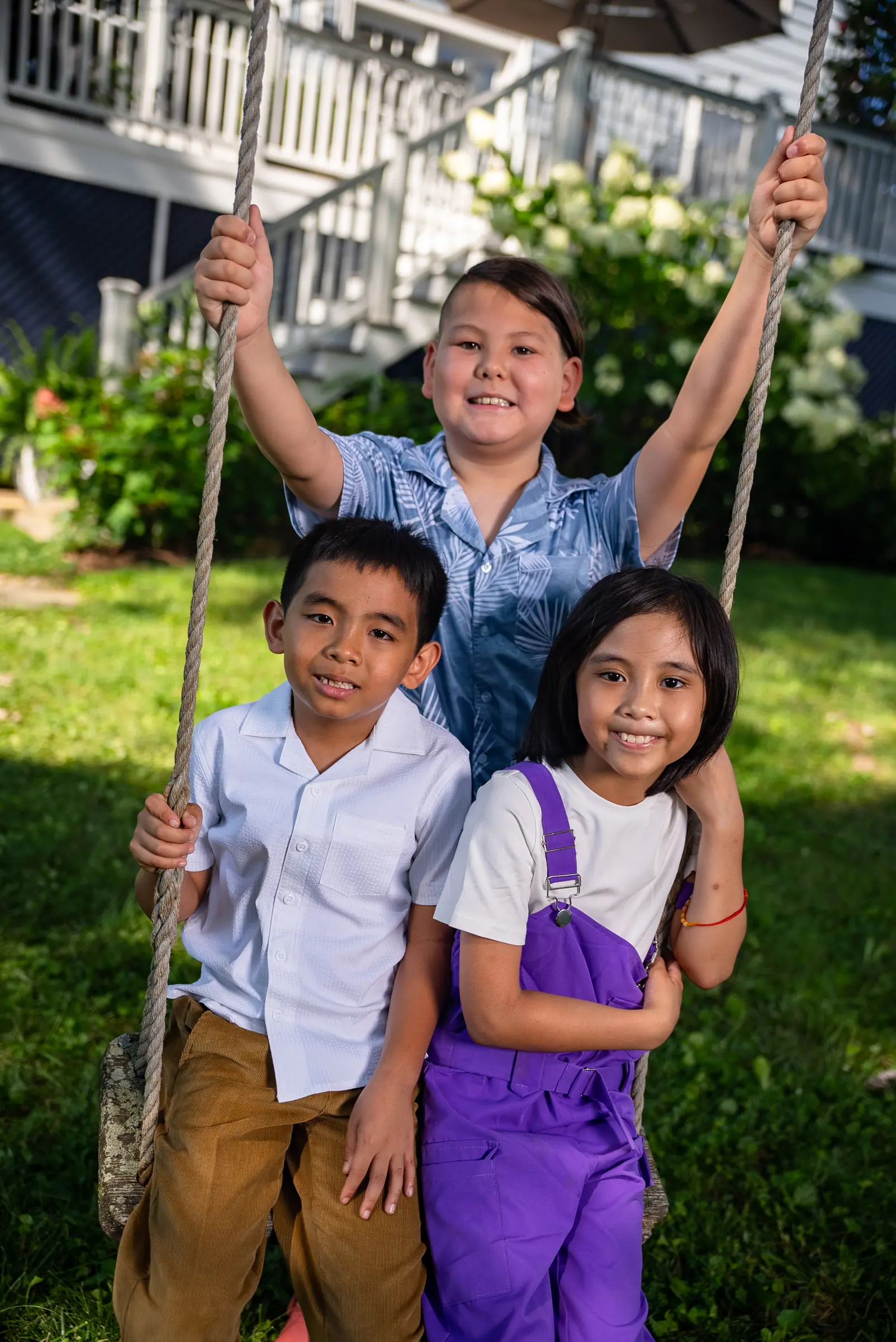 Three siblings on a garden swing
