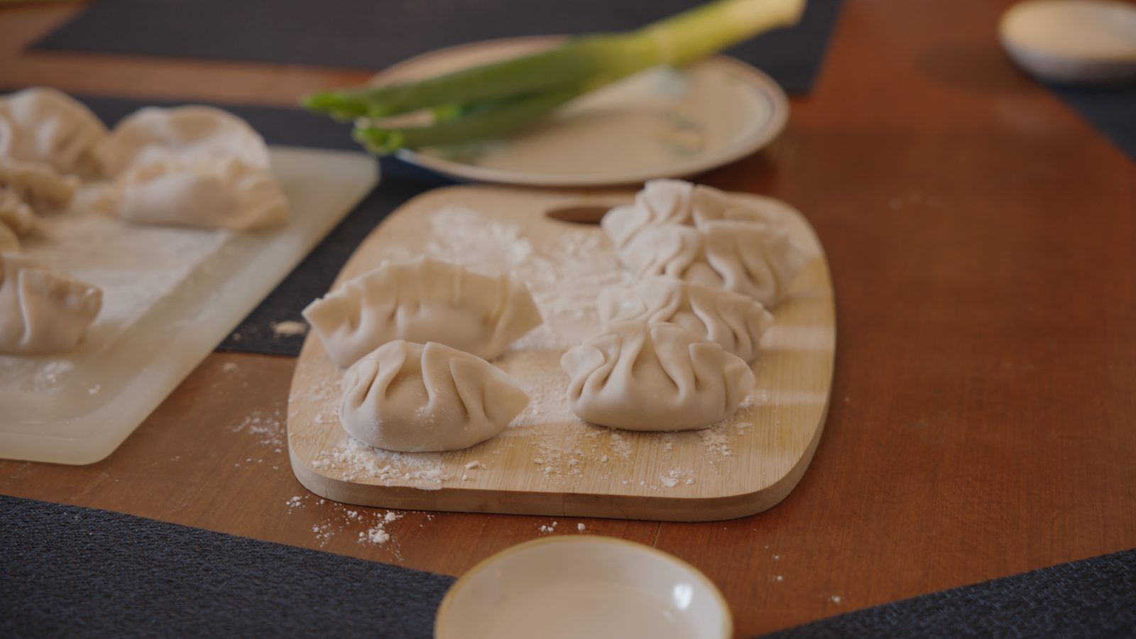 Dumplings being folded on a floured board