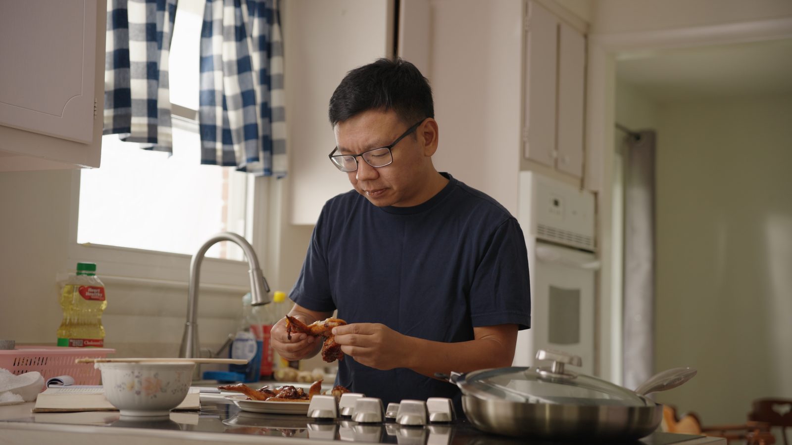 Siwei tasting the finished dish in the kitchen